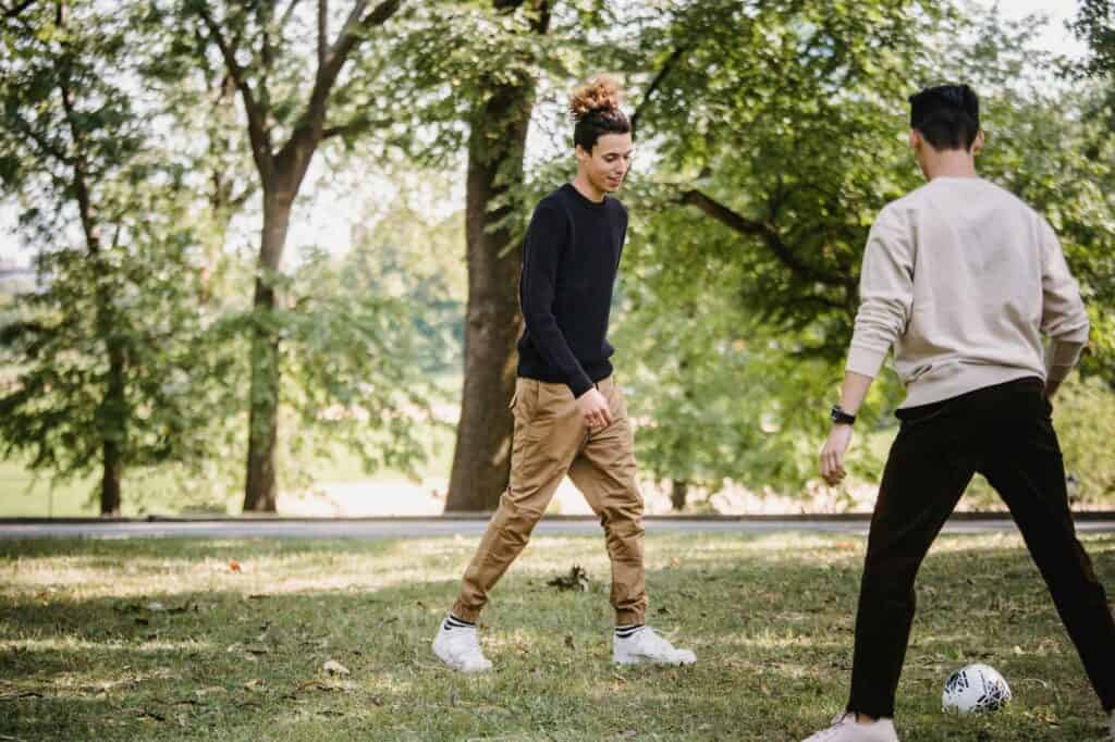 Two boys playing football in a field