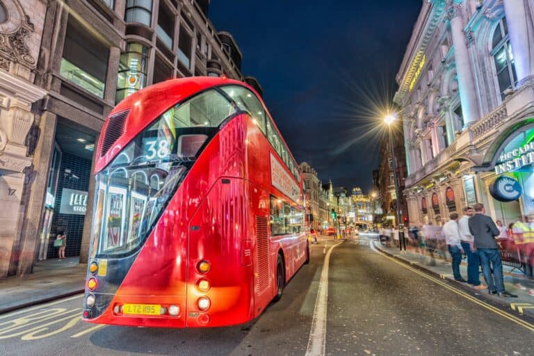 A red double-decker at night in the concept of 'how to use East London's public transport'.