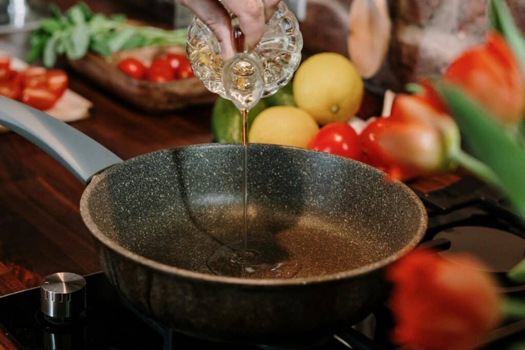Cooking oil poured into a pan in the concept of preparing at-home meals