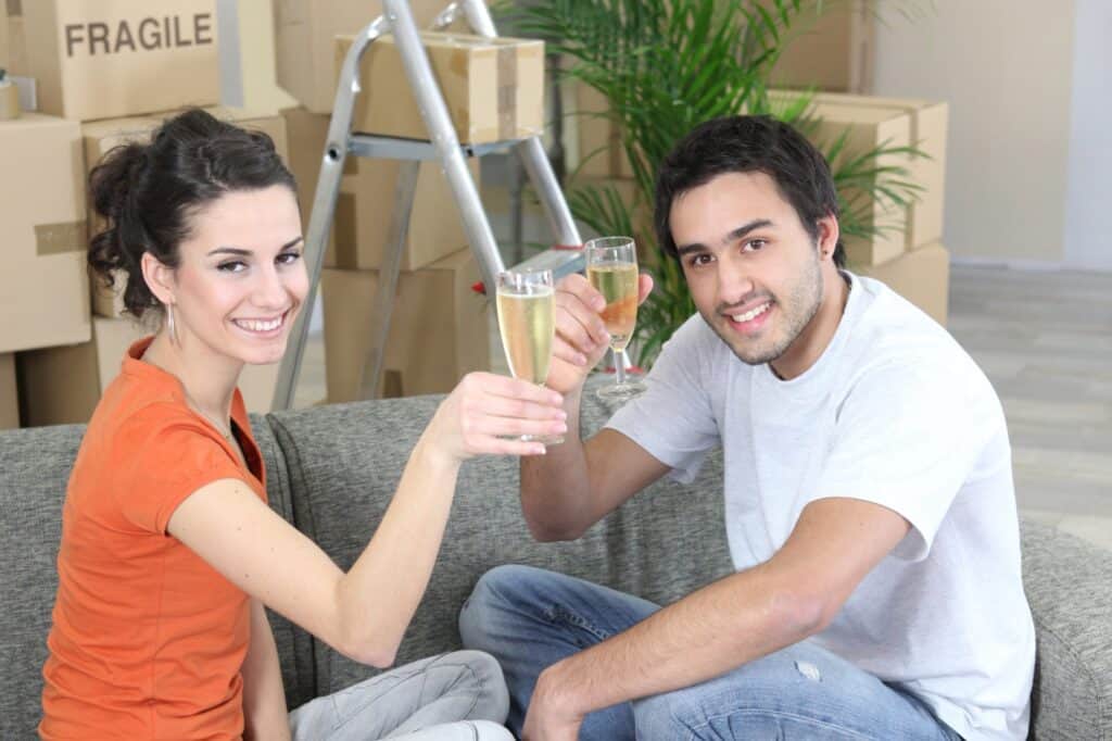 A young couple drinking champagne after the house move