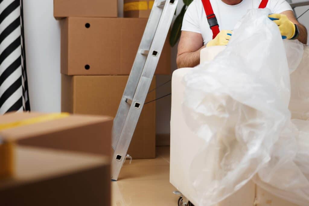 Cropped image of a house mover packing the sofa