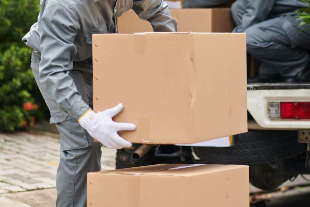 Cropped image of professional house removals crew unloading boxes from the van in the concept of 'what are the benefits of using a professional home removals service'.