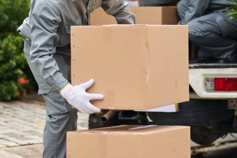 Cropped image of professional house removals crew unloading boxes from the van in the concept of 'what are the benefits of using a professional home removals service'.
