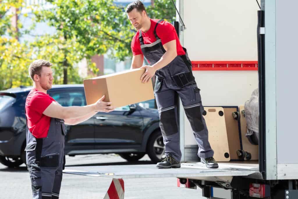 Professional movers unloading boxes and household items on a moving day