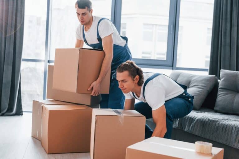House removals crew lifting cartons from a studio flat in the concept of 'What Are Home Removals Services'.