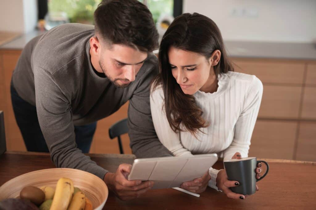 A young couple reviewing the removals' policies in the tablet