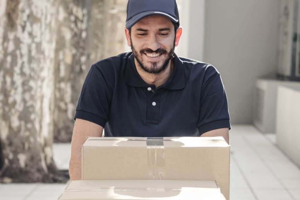 Cropped image of a mover pushing a cart of boxes in the concept of 'How to Choose the Best Home Removals Company'.