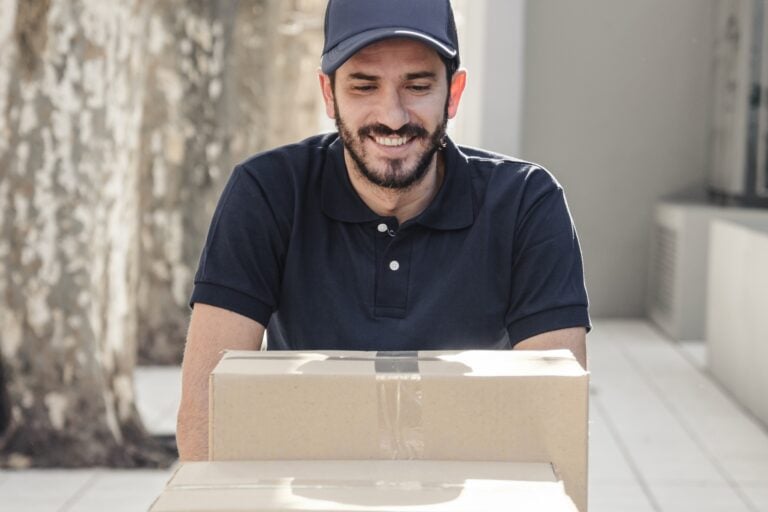 Cropped image of a mover pushing a cart of boxes in the concept of 'How to Choose the Best Home Removals Company'.